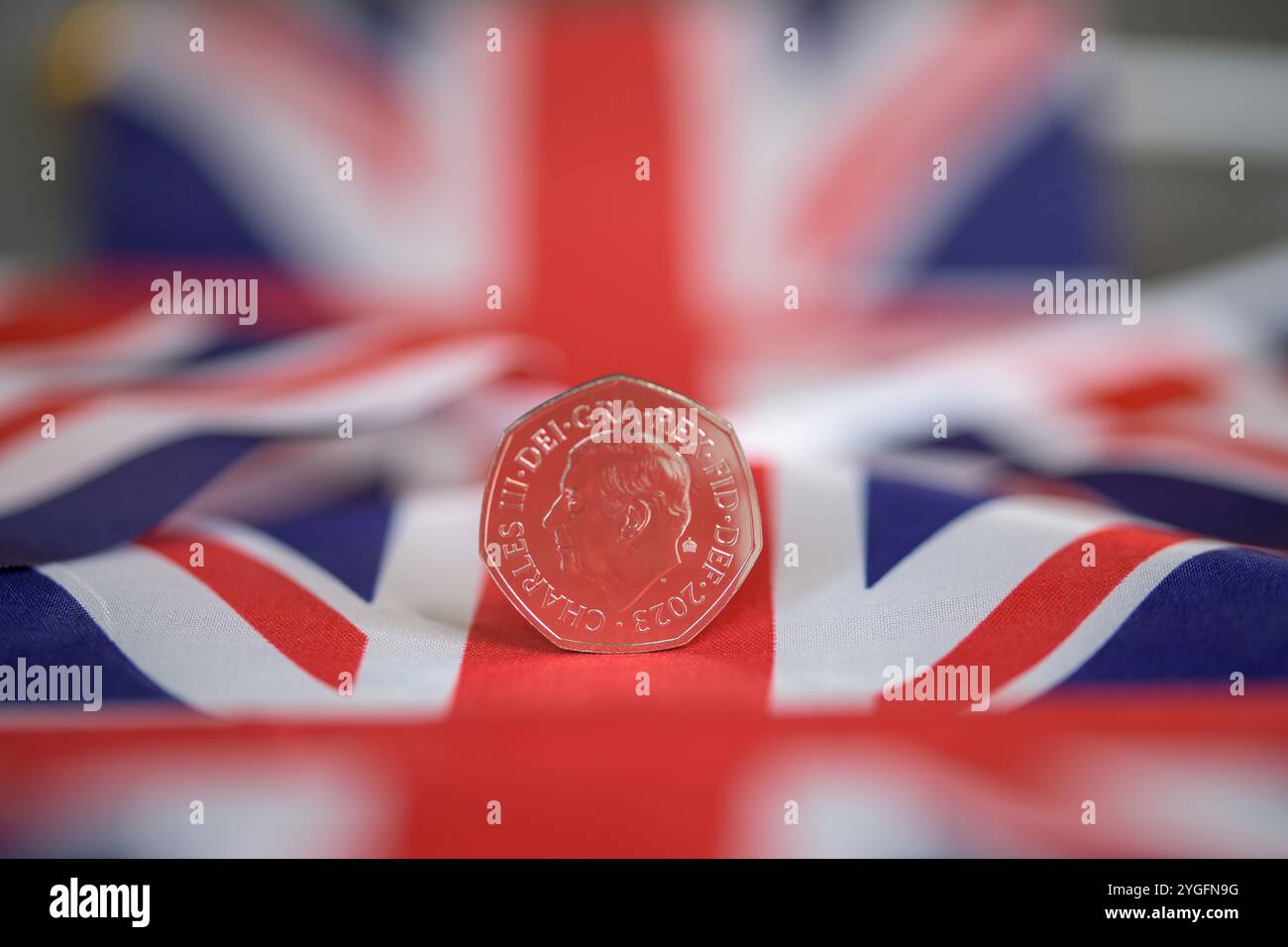 Moneta da 50p, sua altezza reale Re Carlo III, su una bandiera Union Jack Foto Stock
