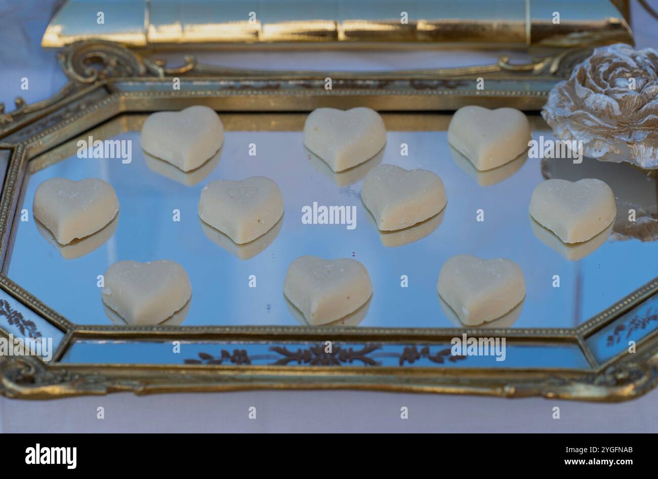 Dolci a cuore bianco su vassoio riflettente - l'amore è ovunque . Concetto di matrimonio Foto Stock