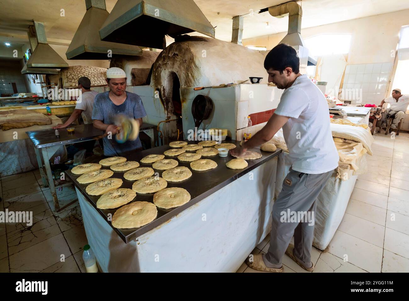 Cuocere pane locale al Chorsu Bazaar. Il Chorsu Bazaar è un grande e duraturo mercato con bancarelle che vendono cibi locali e souvenir, oltre a abbigliamento e articoli per la casa Foto Stock