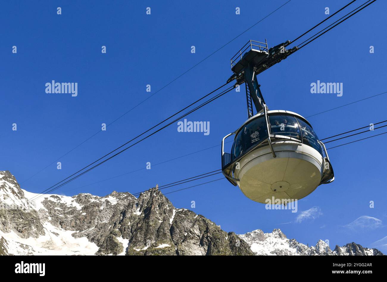 Vista ad angolo basso di una cabina della funivia Skyway Monte bianco che porta gli escursionisti a Pointe Helbronner sul massiccio del Monte bianco, Courmayeur, Aosta, Italia Foto Stock