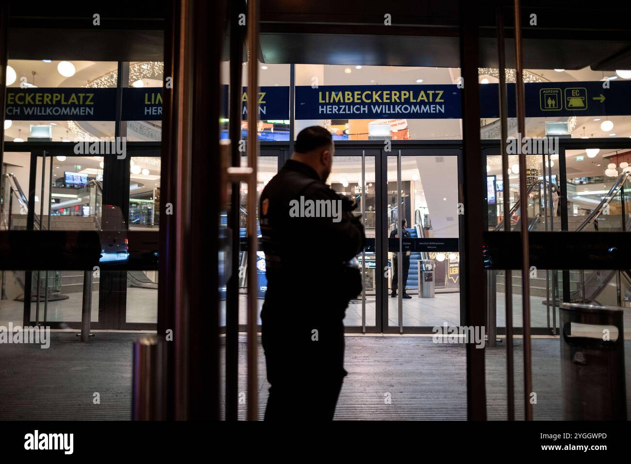 Essen, Germania. 7 novembre 2024. Un addetto alla sicurezza si trova di fronte all'ingresso del centro commerciale 'Limbecker Platz' nel centro della città. Il centro commerciale è stato evacuato a causa della disinnescata di una bomba britannica di cinque centesimi. La bomba inesplosa della seconda guerra mondiale è stata scoperta durante i lavori di costruzione in una piazza del centro città crediti: Fabian Strauch/dpa/Alamy Live News Foto Stock