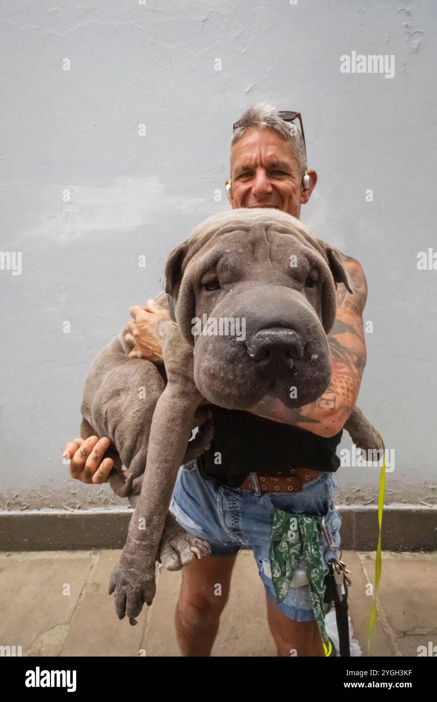 Inghilterra, Kent, Folkestone, Ritratto di uomo che tiene in mano un cane da compagnia di grandi dimensioni Foto Stock