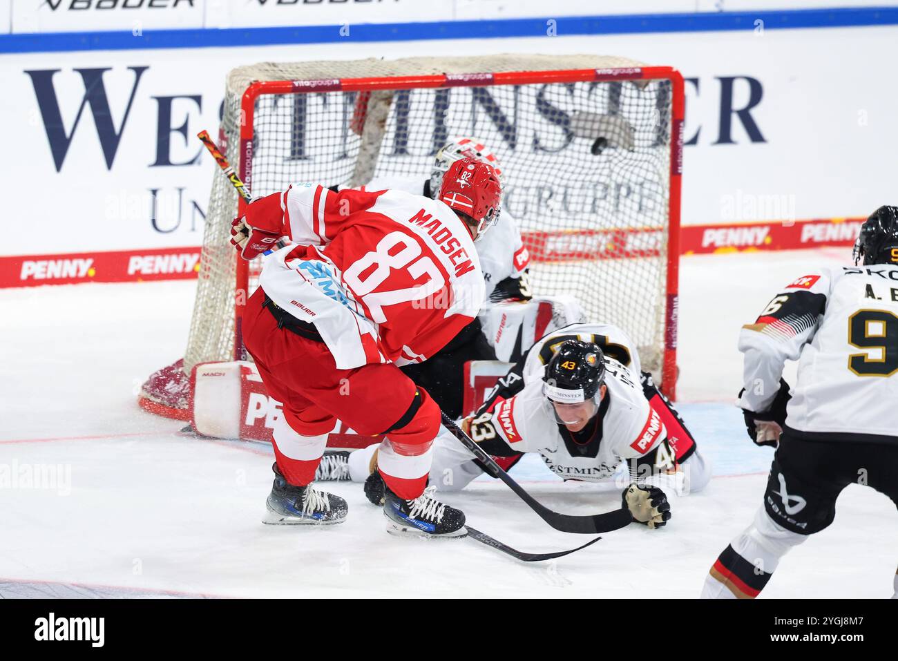 Landshut, Germania. 7 novembre 2024. Hockey su ghiaccio: Coppa Germania, Germania - Danimarca, fase a gironi, giorno partita 1. Il danese David Madsen (l) fa scivolare il puck davanti al tedesco Luca Sennhenn per fare 3:1 per la Danimarca. Crediti: Daniel Löb/dpa/Alamy Live News Foto Stock