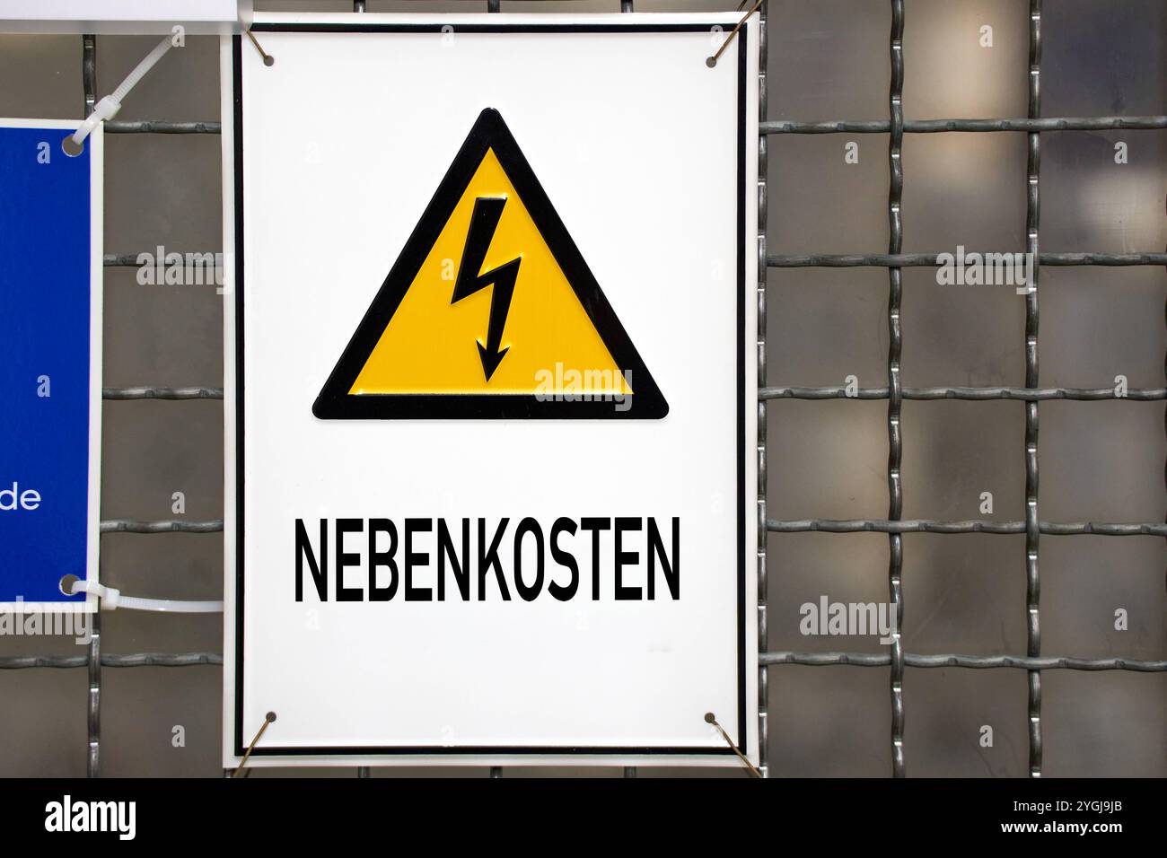 Baviera, Germania - 7 novembre 2024: Spese di servizio, scritte su un cartello con il simbolo dell'elettricità. Simboleggia i costi aggiuntivi del canone di base, come elettricità, acqua calda, riscaldamento e acque reflue, oltre al canone di base. FOTOMONTAGGIO *** Nebenkosten, steht auf einem Schild mit Strom-Symbol. Symbolisiert Nebenkosten zur Kaltmiete wie Strom Warmwasser, Heizung und Abwasser zusätzlich zur Kaltmiete. FOTOMONTAGE Foto Stock