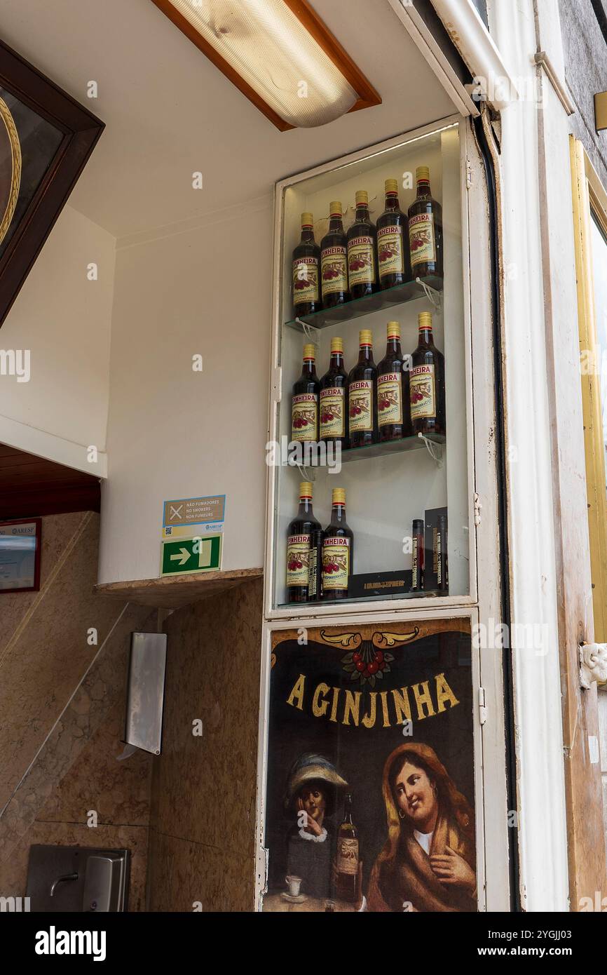 Bottiglie in mostra, il famoso A Ginjinha Bar nel quartiere Baixa, turisti, che servono liquore portoghese, Lisbona, Portogallo. Foto Stock