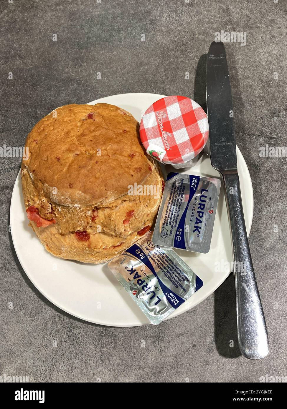 Scone di ciliegia su un piatto laterale con marmellata e burro Foto Stock