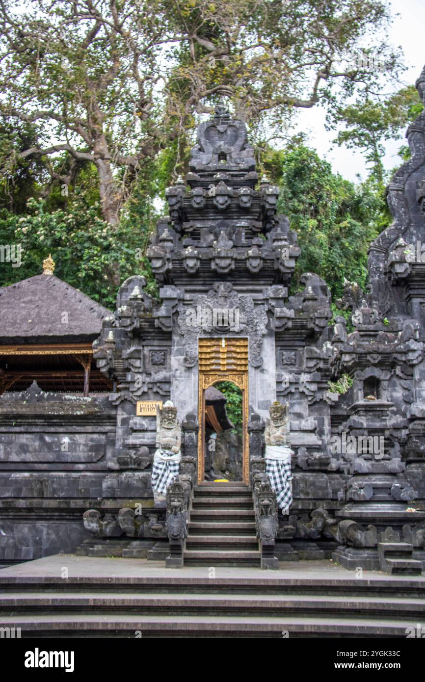 Complesso di templi della fede indù. Tempio in pietra lavica di fronte a una grotta sacra di pipistrelli del tempio di Goa Lawah, Bali, Indonesia Foto Stock