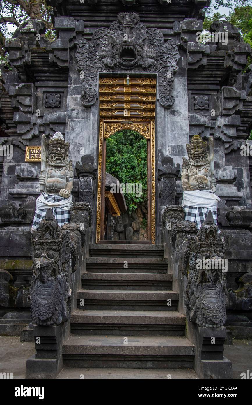 Complesso di templi della fede indù. Tempio in pietra lavica di fronte a una grotta sacra di pipistrelli del tempio di Goa Lawah, Bali, Indonesia Foto Stock
