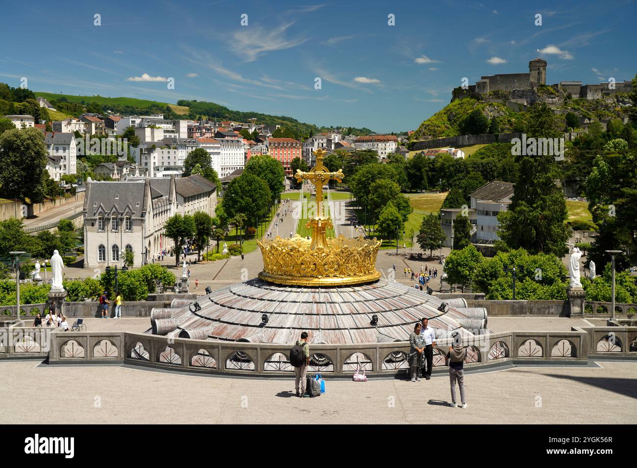 La corona dorata della Basilica del Rosario, la Piazza del Rosario e la fortezza di Château de Lourdes nella città di pellegrinaggio mariana di Lourdes, nei Pirenei, Foto Stock