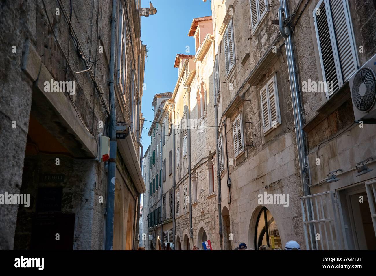 Spalato, Croazia; Octubre,12,2024: Un'affascinante strada stretta nella storica città vecchia di Spalato, Croazia. Il vicolo tortuoso è fiancheggiato da antiche pietre Foto Stock