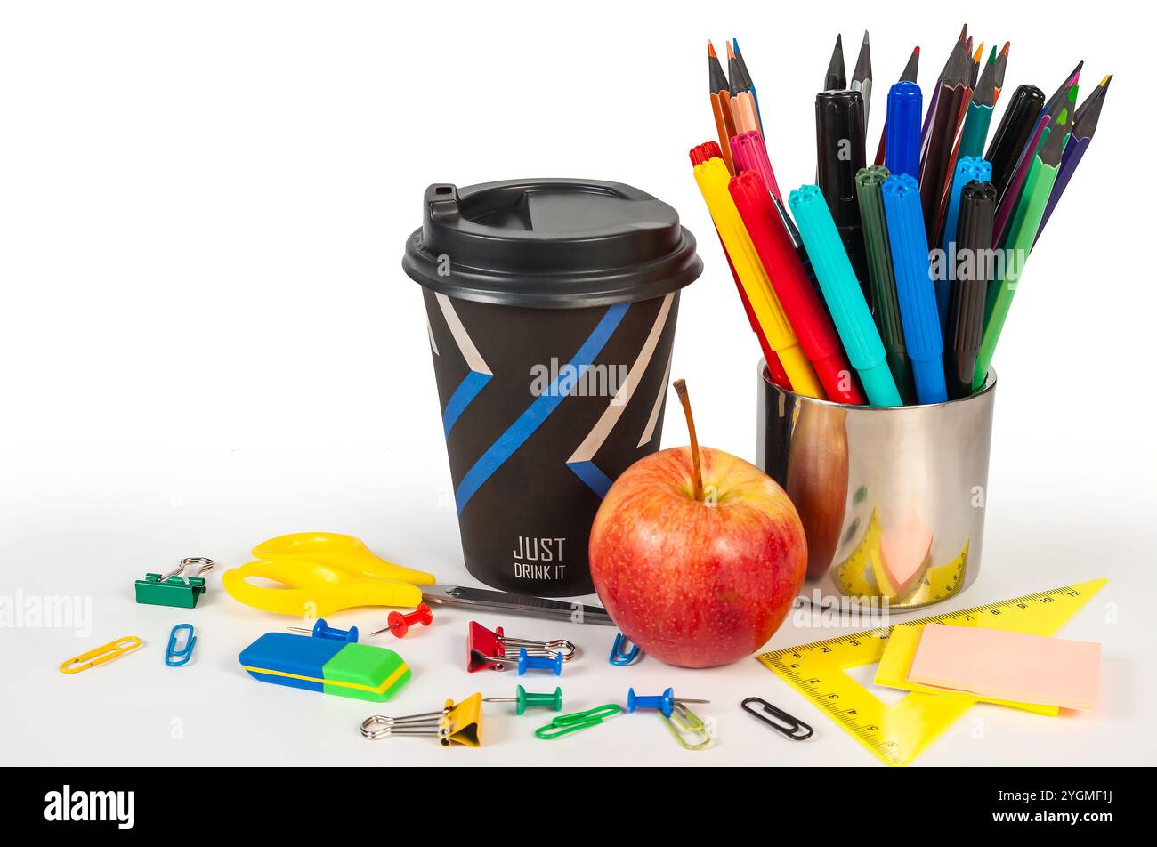 Una collezione di vivaci forniture per ufficio con una tazza di caffè, mela, graffette, fermagli leganti, perni a pressione, cancellatori. Foto Stock Una collezione di vivaci forniture per ufficio con una tazza di caffè, mela, graffette, fermagli leganti, perni a pressione, cancellatori. Foto Stock