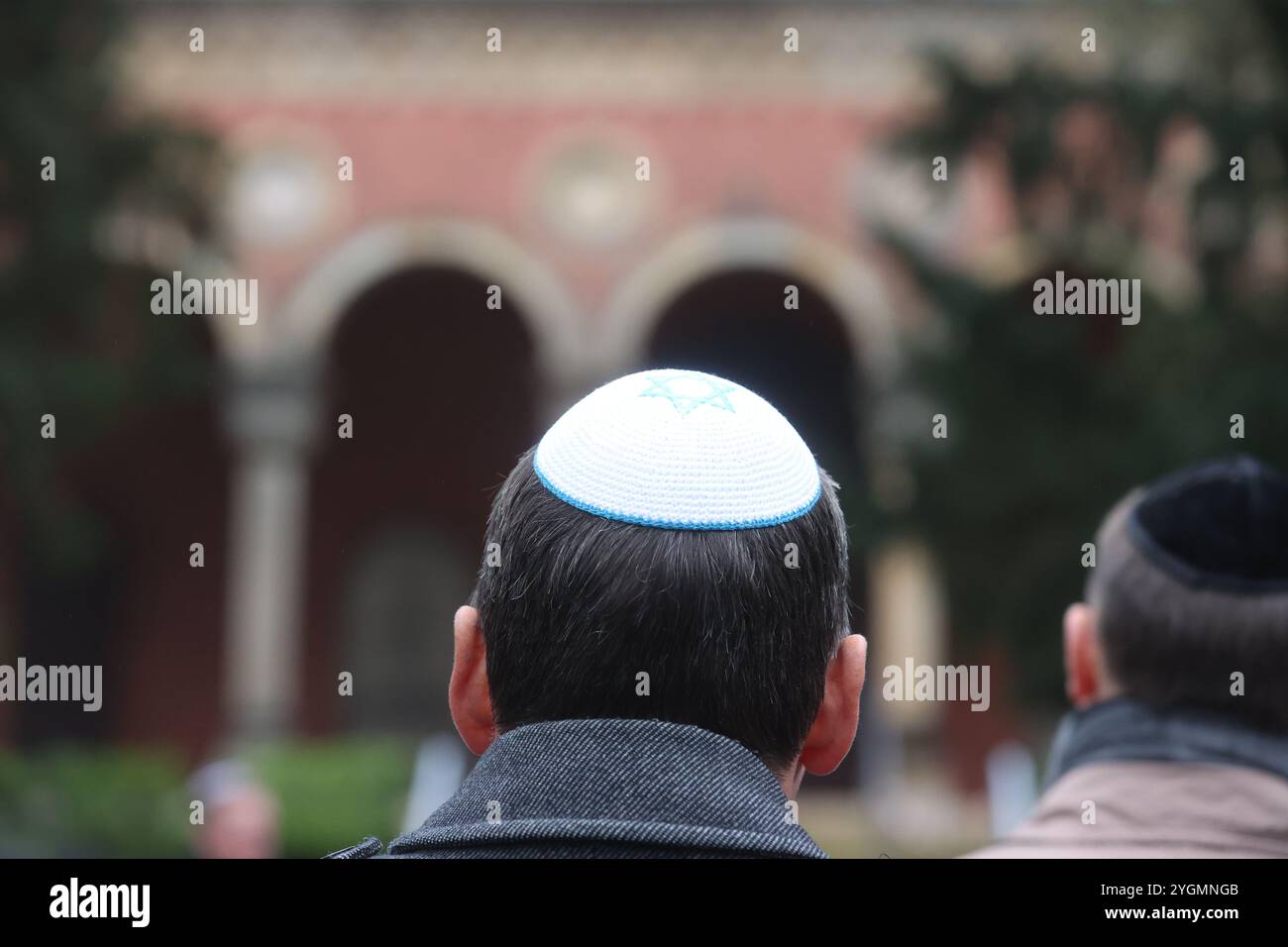 Erfurt, Germania. 8 novembre 2024. Un uomo che indossa un kippah si trova al cimitero ebraico durante una cerimonia di commemorazione per celebrare l'anniversario della notte del pogrom del 1938. Credito: Bodo Schackow/dpa/Alamy Live News Foto Stock