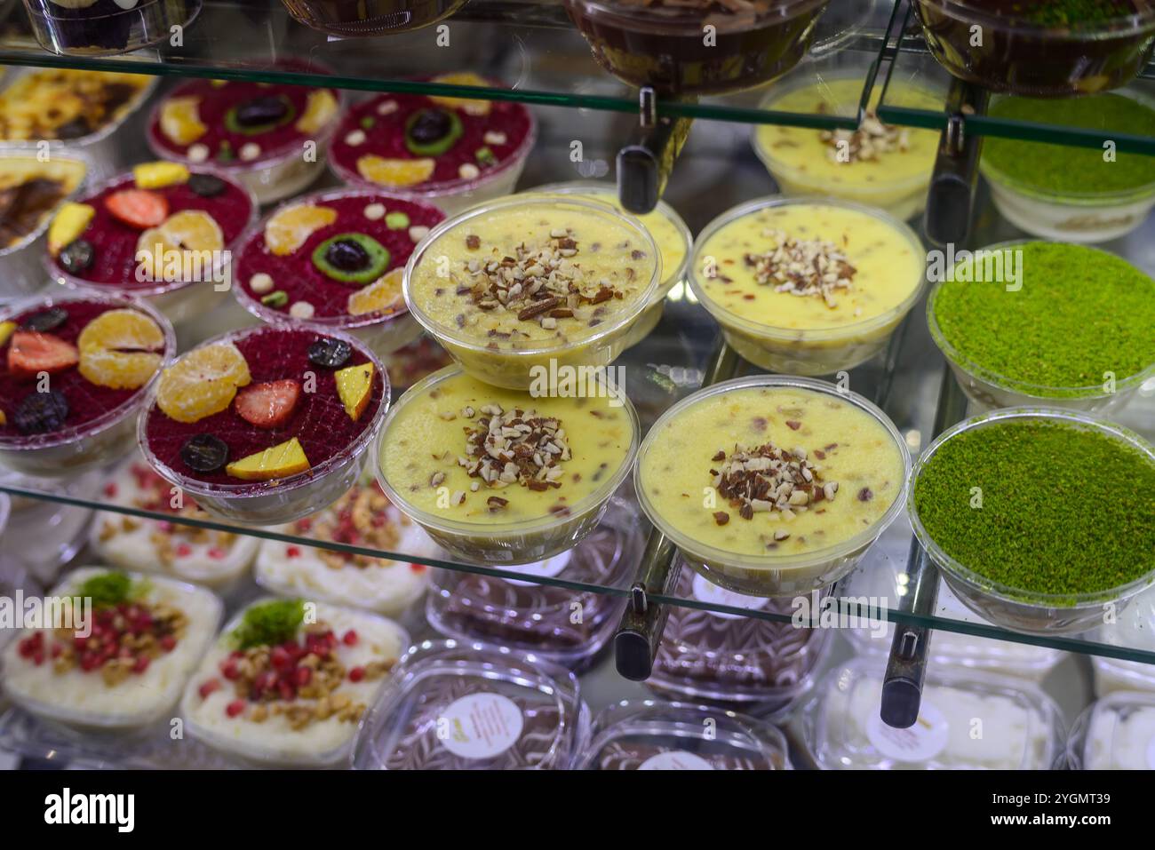 Una varieta' variegata di dessert deliziosi vi attende, con budini cremosi e dolcetti fruttati in un negozio di dessert. Foto Stock