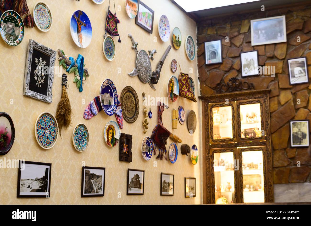 Piatti artigianali e opere d'arte vibranti di cultura adornano le pareti, mostrando un ricco patrimonio e arte. Foto Stock