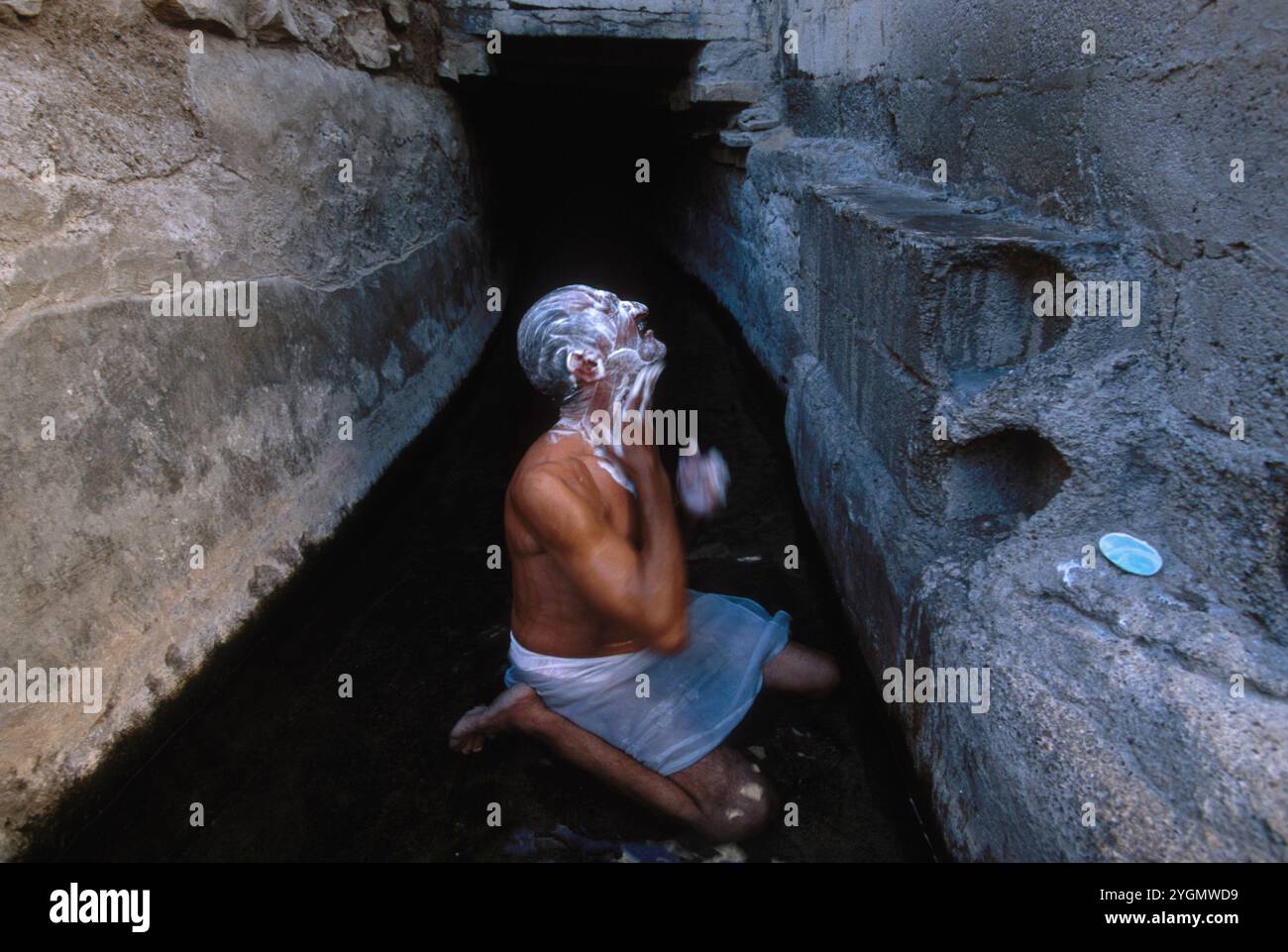 Mirbad Khan che fa il bagno in un canale di irrigazione chiamato falaj a Buraimi, Oman. Il falaj è un'antica forma di irrigazione utilizzata dai Persiani. Foto Stock