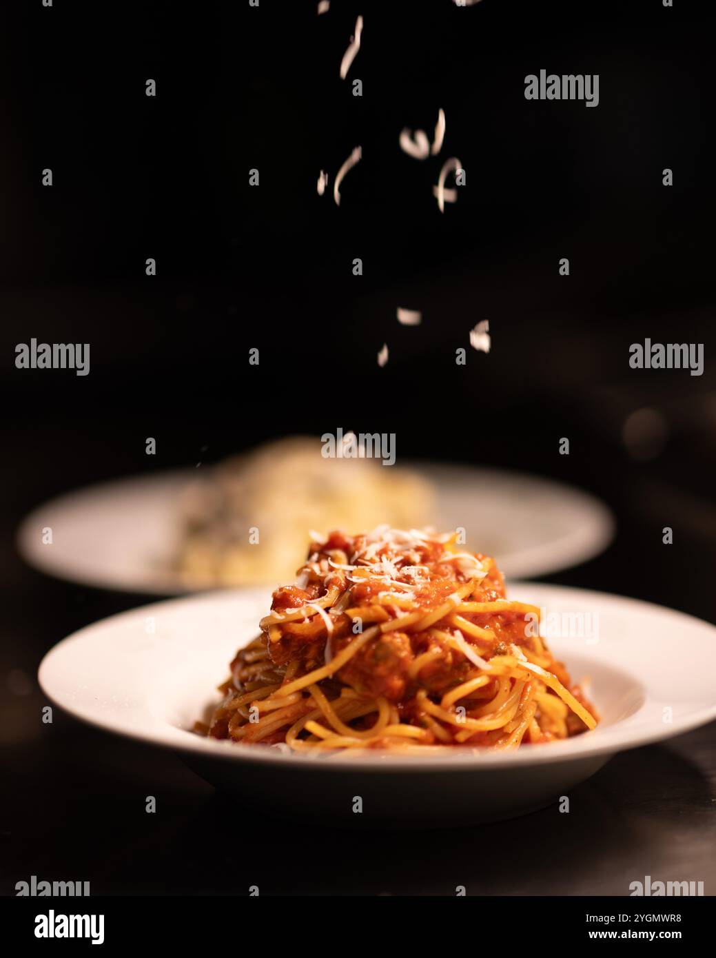 Classici spaghetti italiani conditi con una ricca salsa di pomodoro rosso e una fresca foglia di basilico, un piatto semplice ma saporito che incarna la cucina italiana. Foto Stock
