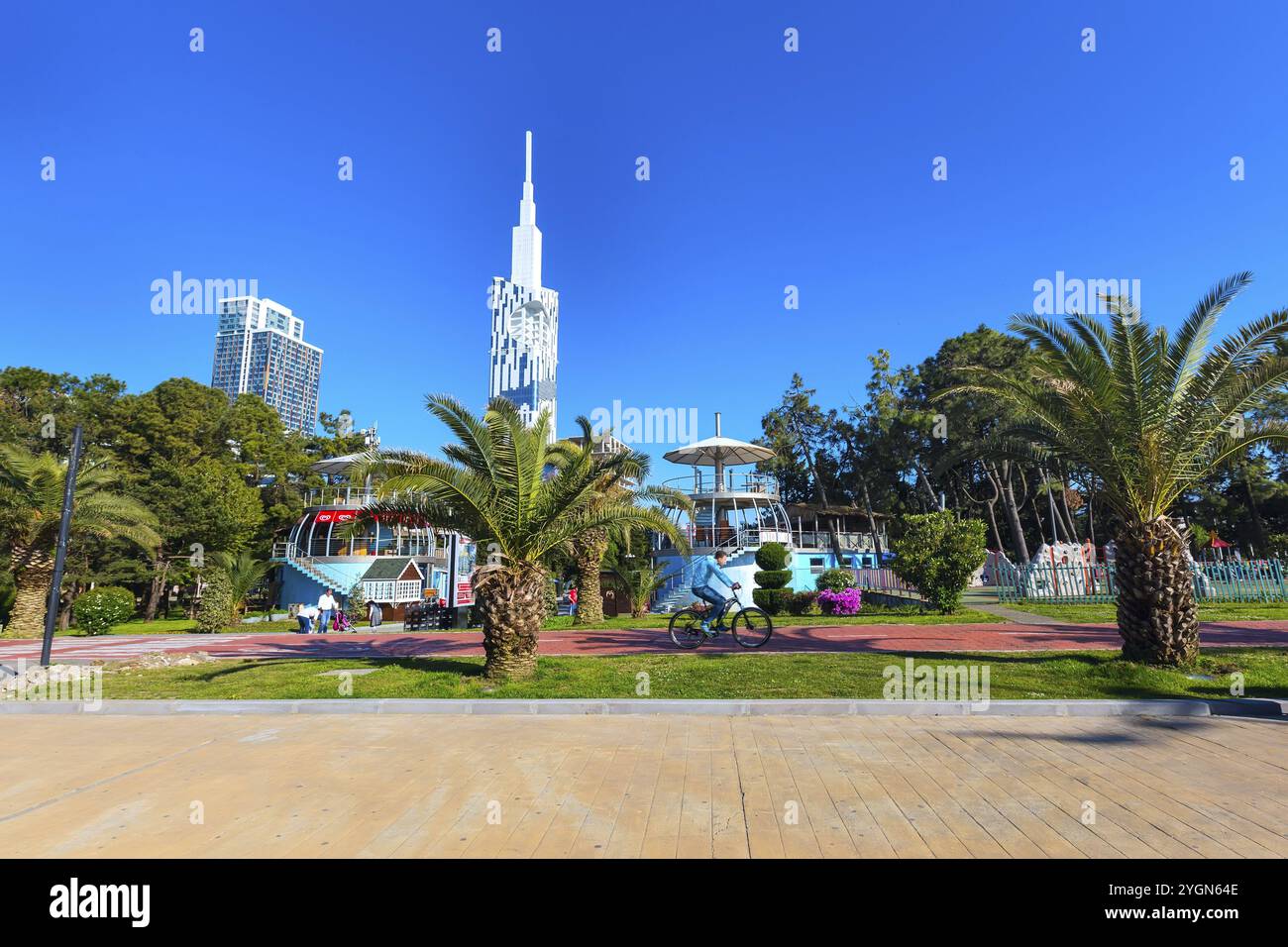 Batumi, Georgia, 30 aprile 2017: Persone che camminano nel parco con palme vicino al lungomare della località estiva georgiana, in Asia Foto Stock
