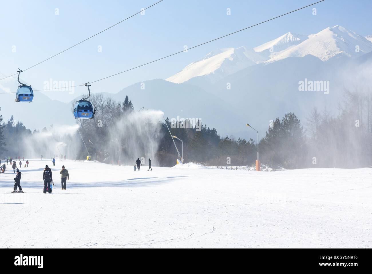 Bansko, Bulgaria, 11 febbraio 2023: Panorama della stazione sciistica invernale bulgara con cabine cabine di cabinovia, vista sulle cime dei monti Pirin e pista, Europa Foto Stock
