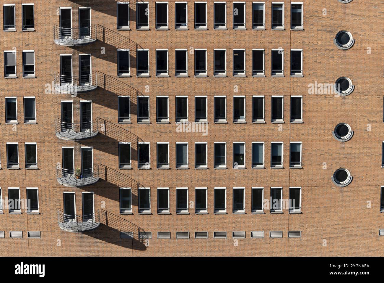 Edificio in mattoni rossi con balconi e finestre quadrate e rotonde a Speicherstadt, HafenCity, città anseatica di Amburgo, Amburgo, Germania, Europa Foto Stock