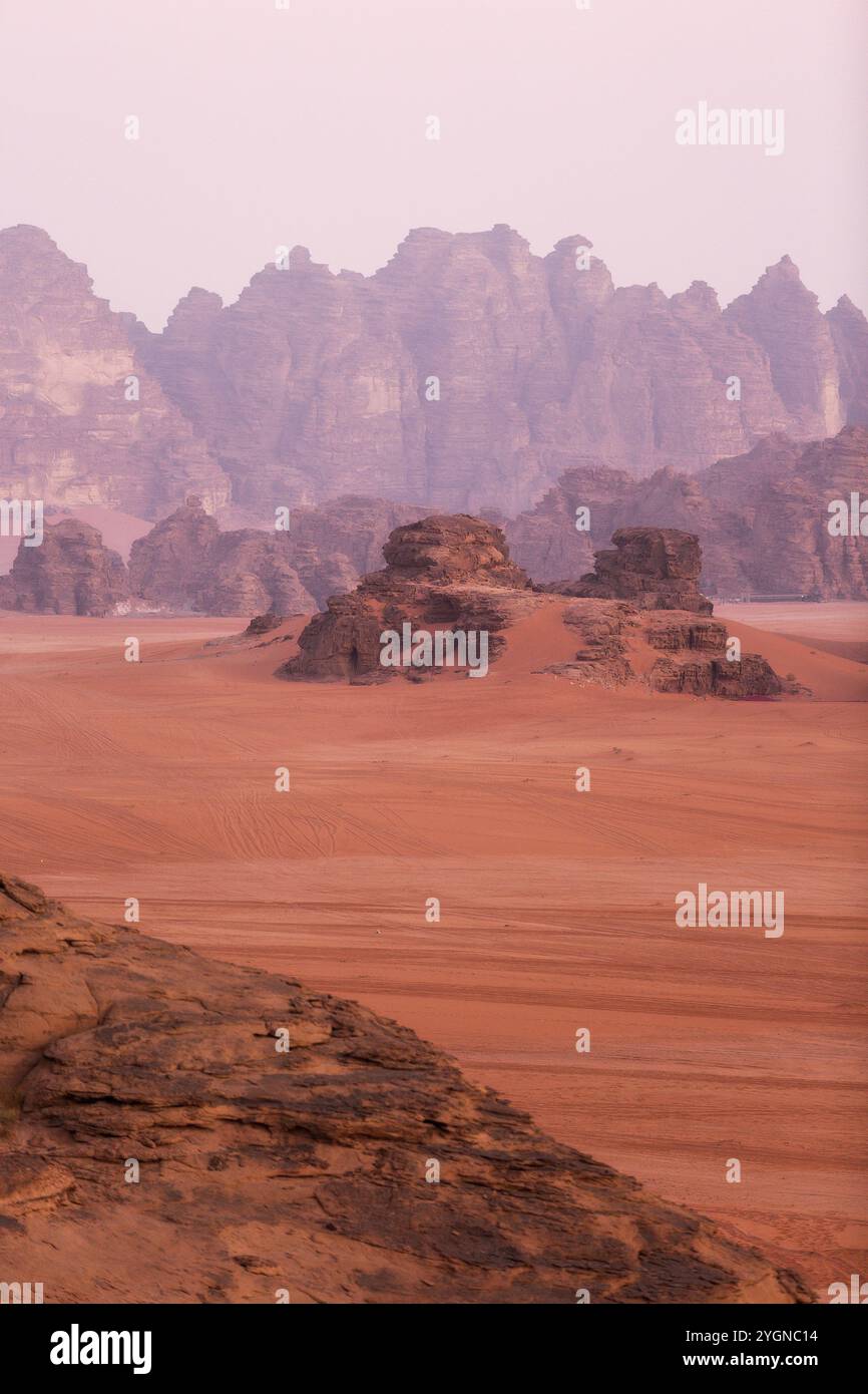 Wadi Rum, Giordania. Il paesaggio del deserto di sabbia arancione e le montagne rocciose all'alba Foto Stock