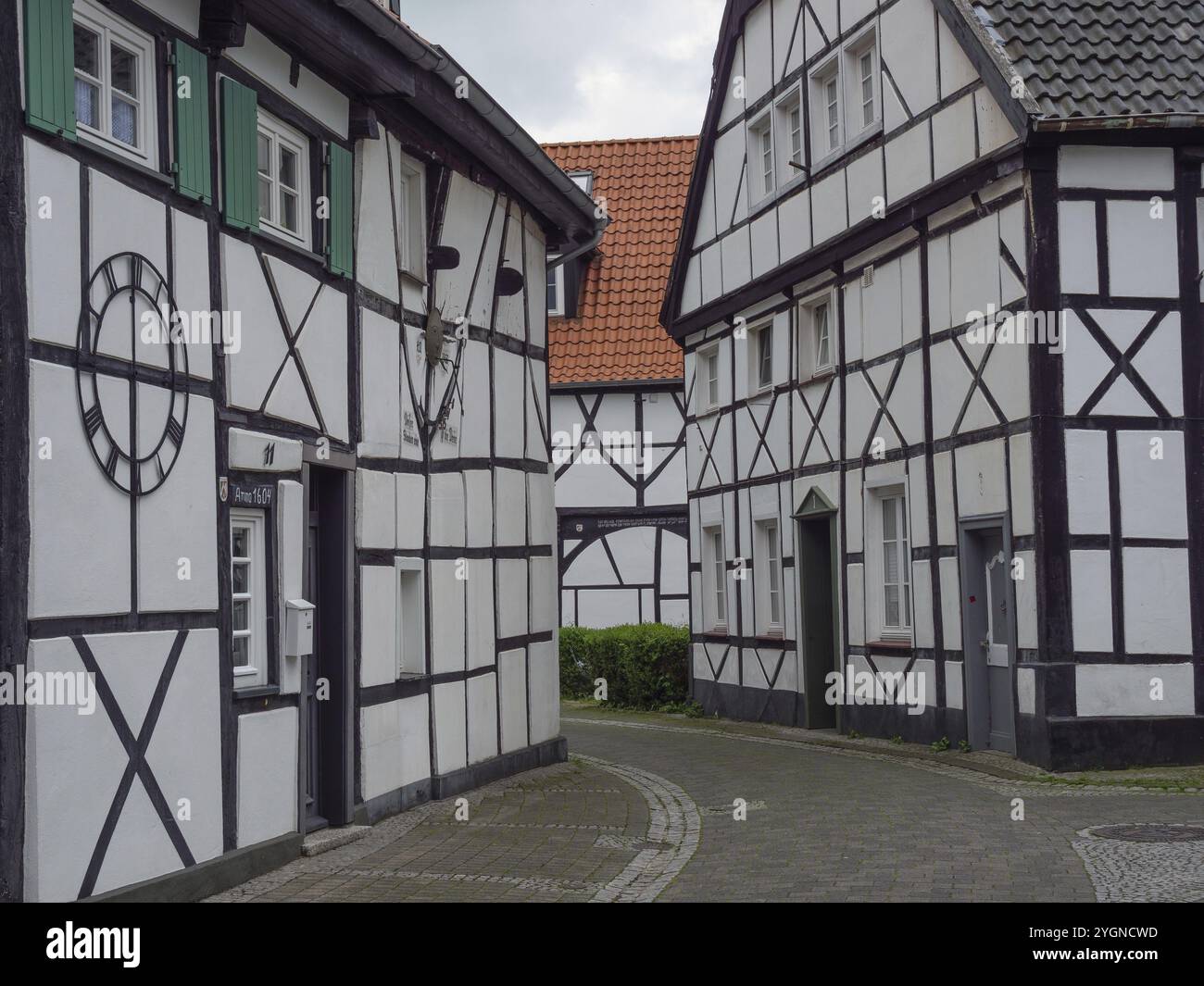 Vicolo stretto fiancheggiato da tradizionali case in legno che conducono ad un cortile, Herten, Renania settentrionale-Vestfalia, Germania, Europa Foto Stock