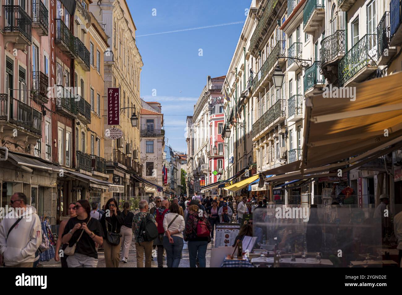 Vivace via dello shopping a Lisbona, vivace via della città con molte persone, circondata da edifici colorati sotto un cielo azzurro, Lisbona, Portogallo, Europ Foto Stock