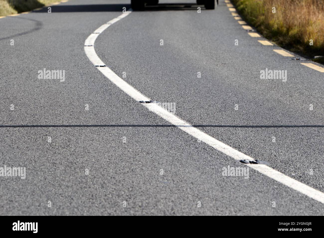 singola linea bianca ininterrotta nel mezzo della strada con catseyes, contea di donegal, repubblica d'irlanda Foto Stock