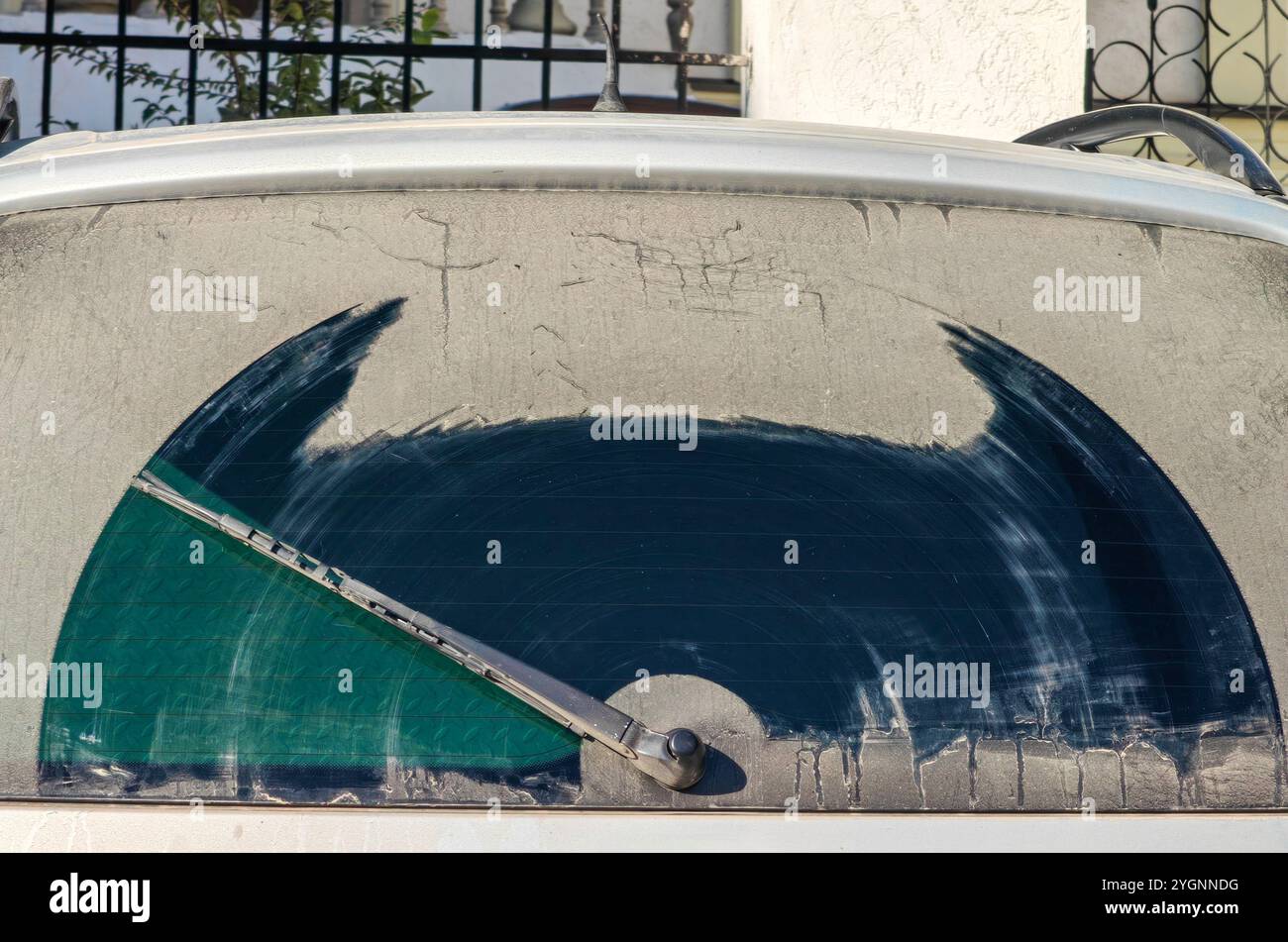 protezione lunotto telaio cristallo sporco, tergicristallo. parte della macchina dal retro. forma astratta di batman. lavate la vostra auto concept. Foto Stock protezione lunotto telaio cristallo sporco, tergicristallo. parte della macchina dal retro. forma astratta di batman. lavate la vostra auto concept. Foto Stock
