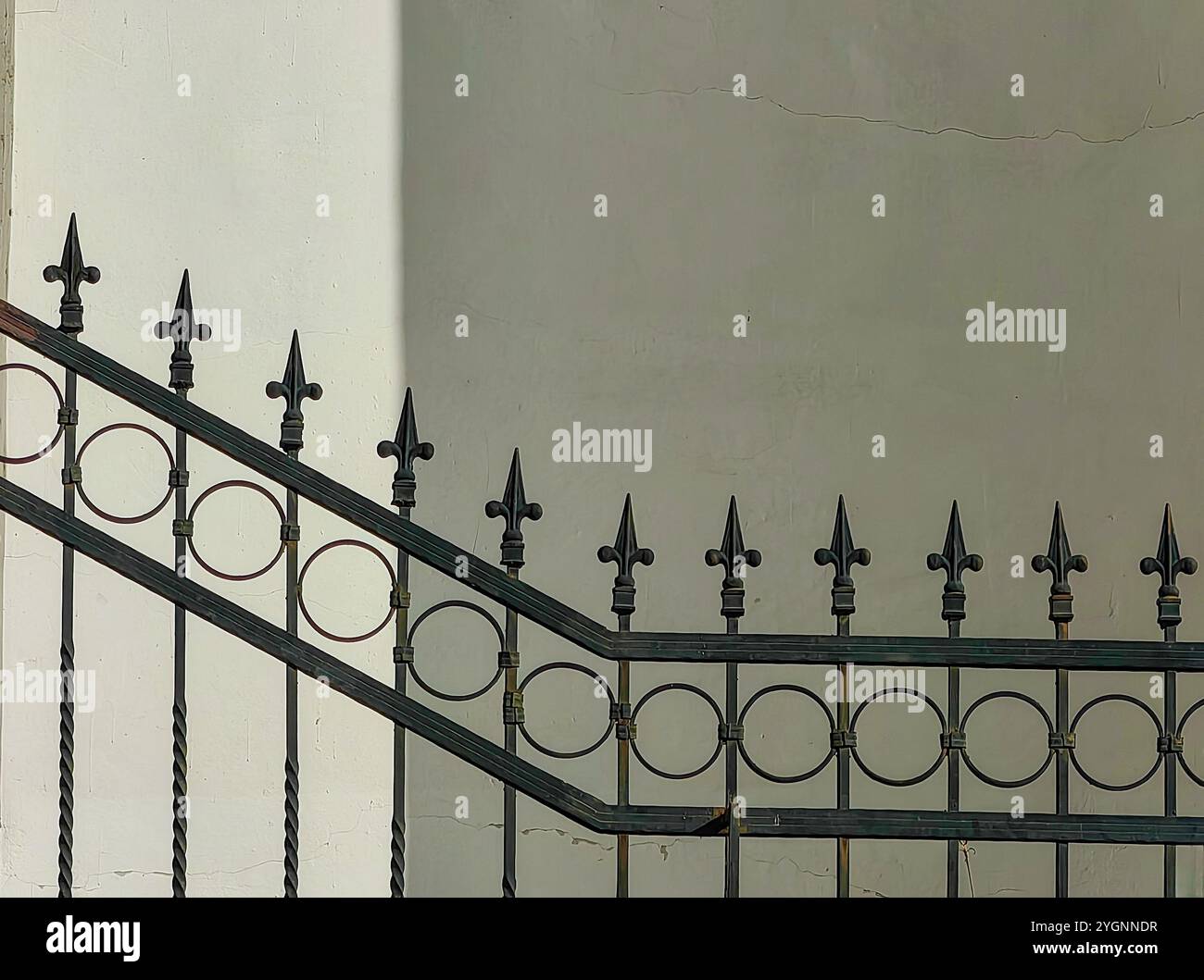 Simmetria ombreggiata: Fence di ferro contro luce Foto Stock