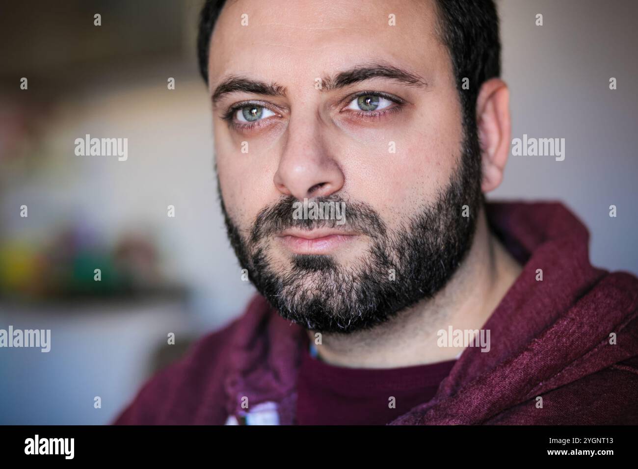 Primo piano ritratto di un uomo barbuto che trasuda fiducia e determinazione, catturando il suo sguardo forte e risoluto Foto Stock