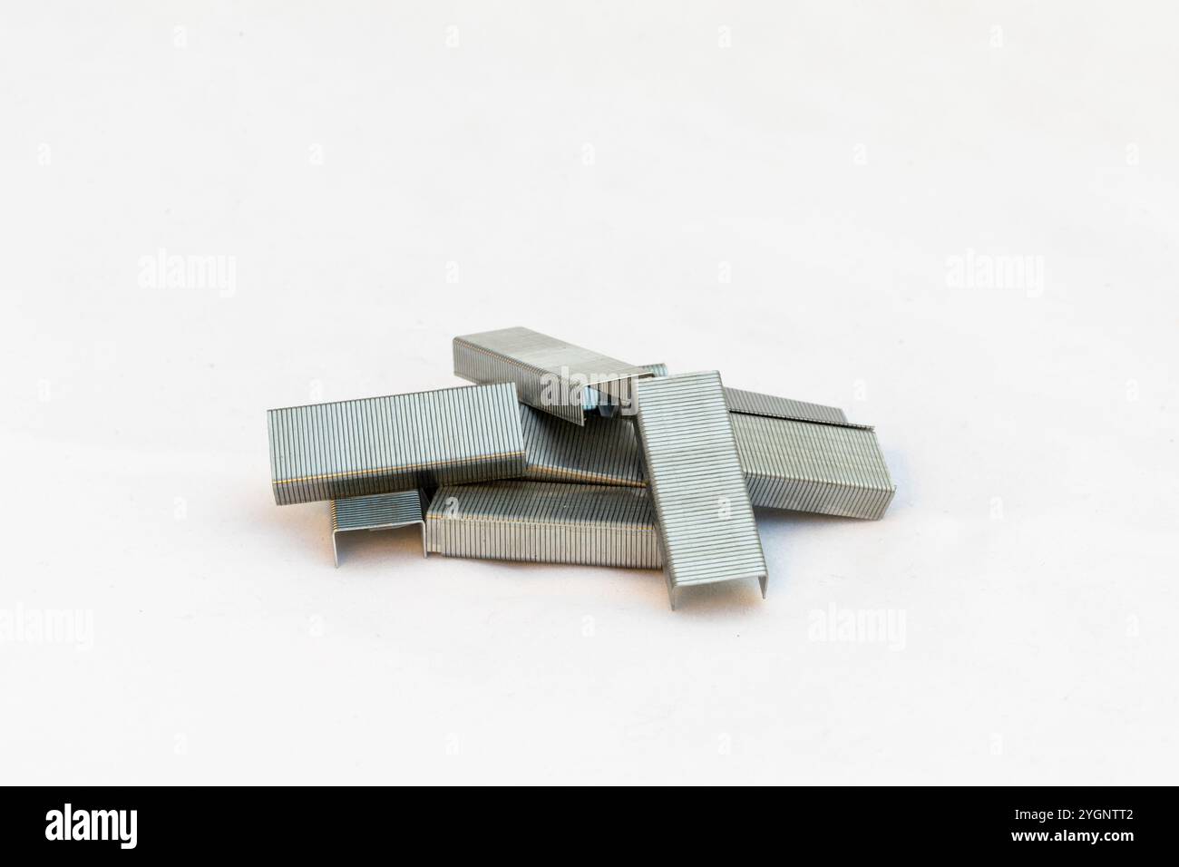 Punti metallici per cucitrice isolati su sfondo bianco Foto Stock