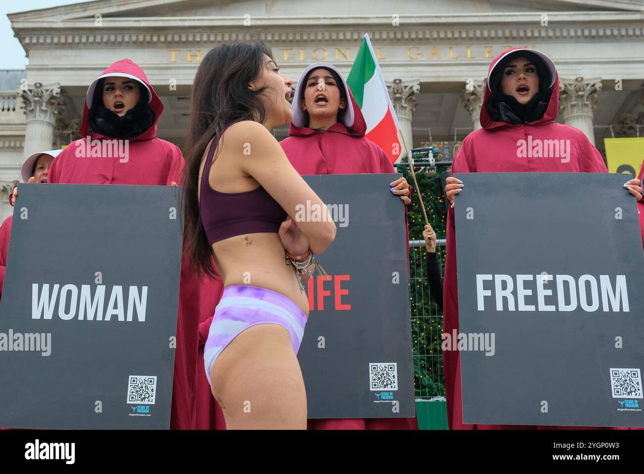 Londra, Regno Unito. 8 novembre 2024. I manifestanti vestiti con i costumi della Handmaid's tale guidati da una donna che rappresenta lo studente Ahoo Daryaei marciarono in solidarietà con il 30enne che fu fermato dalla polizia morale per essere stato "vestito impropriamente all'Università Azad Islamica di Teheran. La signora Daryaei ha tolto i suoi vestiti esterni per protestare contro il suo trattamento ed è stata arrestata dalle autorità con dove si trovava l'attuale lisconosciuta. Credito: Fotografia dell'undicesima ora/Alamy Live News Foto Stock