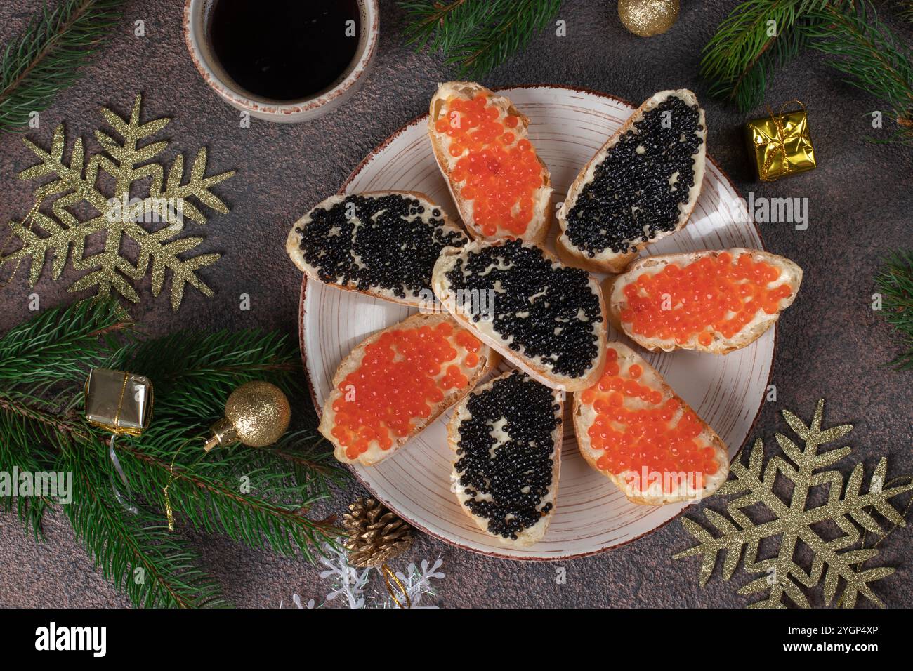Panini fatti in casa con caviale rosso e nero su toast di pane bianco su piatto rotondo su sfondo marrone, vista dall'alto Foto Stock
