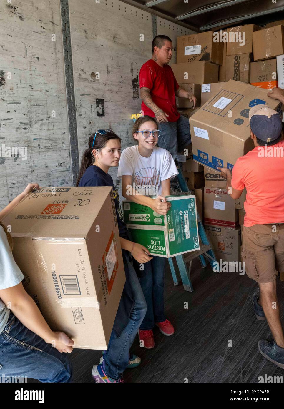 Marion Texas USA, 6 novembre 2024: Adolescenti e adulti provenienti dalle chiese della Chiesa evangelica Luterana d'America (ELCA) del sud-ovest del Texas Synod maneggiano scatole di trapunte fatte in casa, kit scolastici e altri materiali consegnati dalle chiese della zona. La raccolta annuale delle forniture viene confezionata in camion per la consegna nelle aree colpite da catastrofi servite da enti di beneficenza luterani negli Stati Uniti e in Africa. ©Bob Daemmrich Foto Stock Marion Texas USA, 6 novembre 2024: Adolescenti e adulti provenienti dalle chiese della Chiesa evangelica Luterana d'America (ELCA) del sud-ovest del Texas Synod maneggiano scatole di trapunte fatte in casa, kit scolastici e altri materiali consegnati dalle chiese della zona. La raccolta annuale delle forniture viene confezionata in camion per la consegna nelle aree colpite da catastrofi servite da enti di beneficenza luterani negli Stati Uniti e in Africa. ©Bob Daemmrich Foto Stock