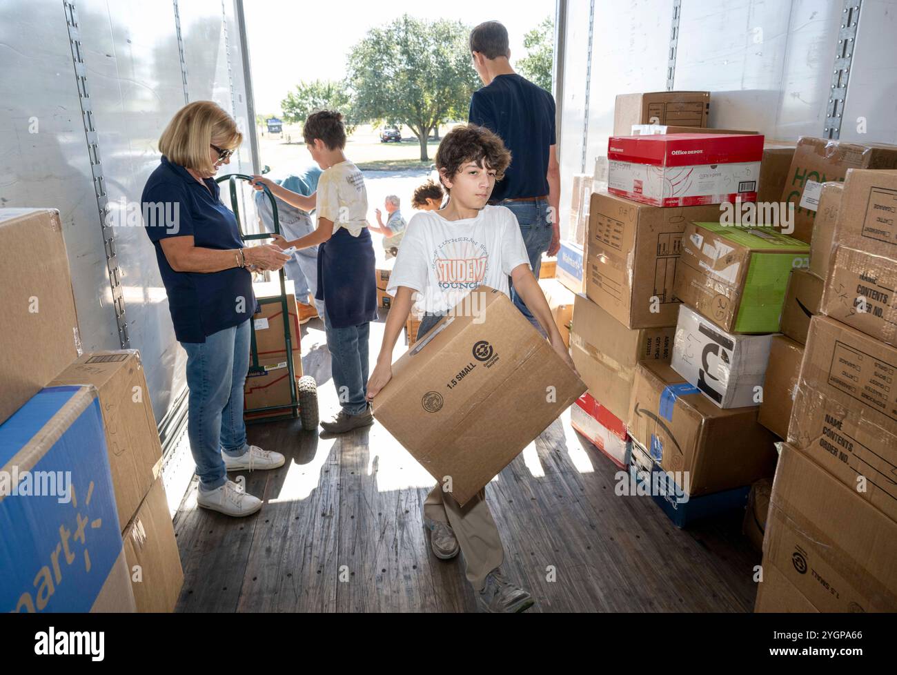 Marion Texas USA, 6 novembre 2024: Adolescenti e adulti provenienti dalle chiese della Chiesa evangelica Luterana d'America (ELCA) del sud-ovest del Texas Synod maneggiano scatole di trapunte fatte in casa, kit scolastici e altri materiali consegnati dalle chiese della zona. La raccolta annuale delle forniture viene confezionata in camion per la consegna nelle aree colpite da catastrofi servite da enti di beneficenza luterani negli Stati Uniti e in Africa. ©Bob Daemmrich Foto Stock Marion Texas USA, 6 novembre 2024: Adolescenti e adulti provenienti dalle chiese della Chiesa evangelica Luterana d'America (ELCA) del sud-ovest del Texas Synod maneggiano scatole di trapunte fatte in casa, kit scolastici e altri materiali consegnati dalle chiese della zona. La raccolta annuale delle forniture viene confezionata in camion per la consegna nelle aree colpite da catastrofi servite da enti di beneficenza luterani negli Stati Uniti e in Africa. ©Bob Daemmrich Foto Stock
