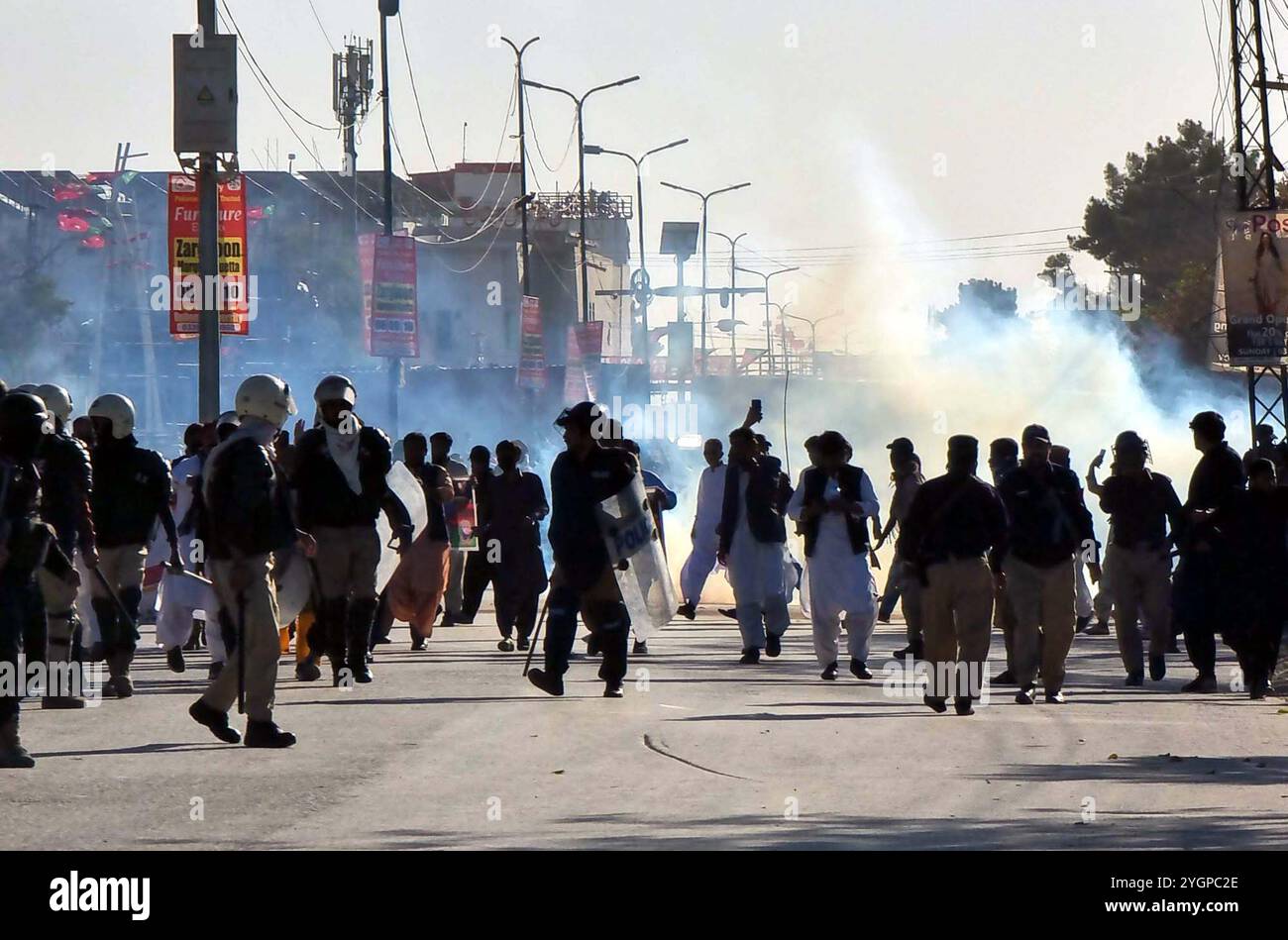 I funzionari di polizia ripristinano la carica di testimone e sparano gas lacrimogeni per respingere i manifestanti durante la manifestazione Tehreek-e-Insaf (PTI), a Quetta venerdì 8 novembre 2024. L'amministrazione distrettuale di Quetta ha imposto un divieto al raduno pianificato del Pakistan Tehreek-e-Insaf (PTI), citando gravi preoccupazioni per la sicurezza. Le autorità hanno stabilito una forte presenza della polizia intorno al campo di hockey e alle aree circostanti, con gli agenti che sigillano l'ingresso principale del locale e bloccano i percorsi che portano al luogo del rally. Foto Stock