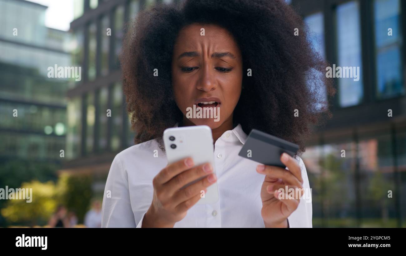 Triste turbata afroamericana donna donna d'affari utente di telefono cellulare smartphone carta di credito credito finanza virtuale problema errore perdita Foto Stock