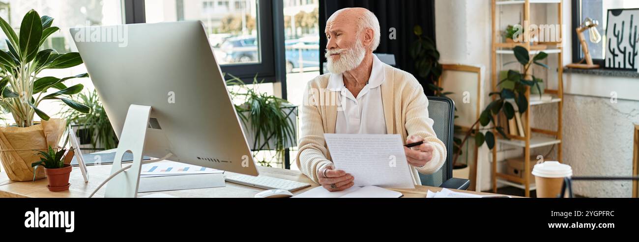 Un uomo d'affari anziano in un elegante abbigliamento casual esamina attentamente i documenti alla sua scrivania in un ufficio elegante. Foto Stock
