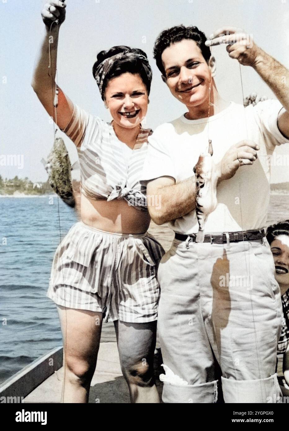 Gita di pesca del Labor Day del 1946; una giovane coppia su una barca che regge 2 piccoli pesci. Foto Stock