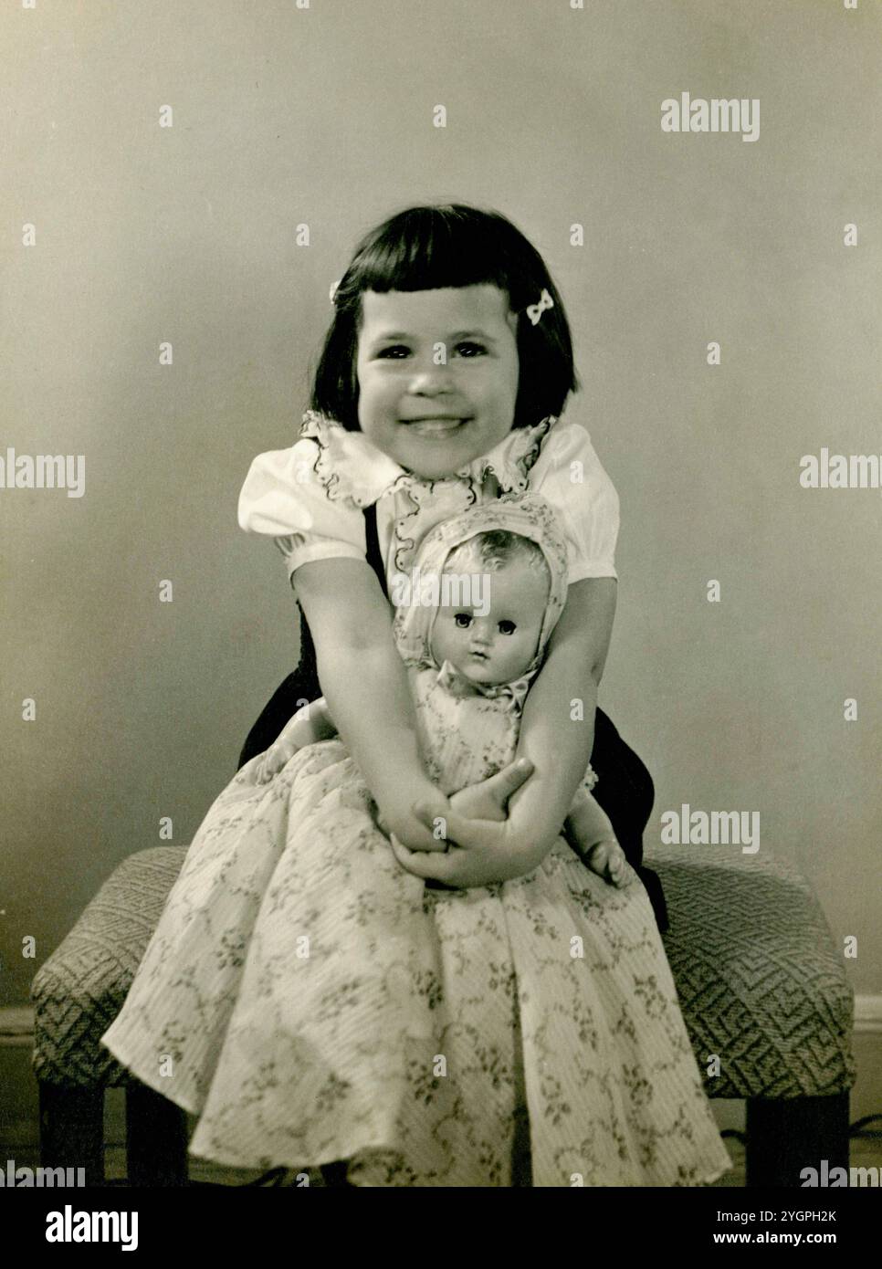 Bambina di tre anni che tiene in mano la sua nuova bambola, il 24 dicembre 1950. Foto Stock