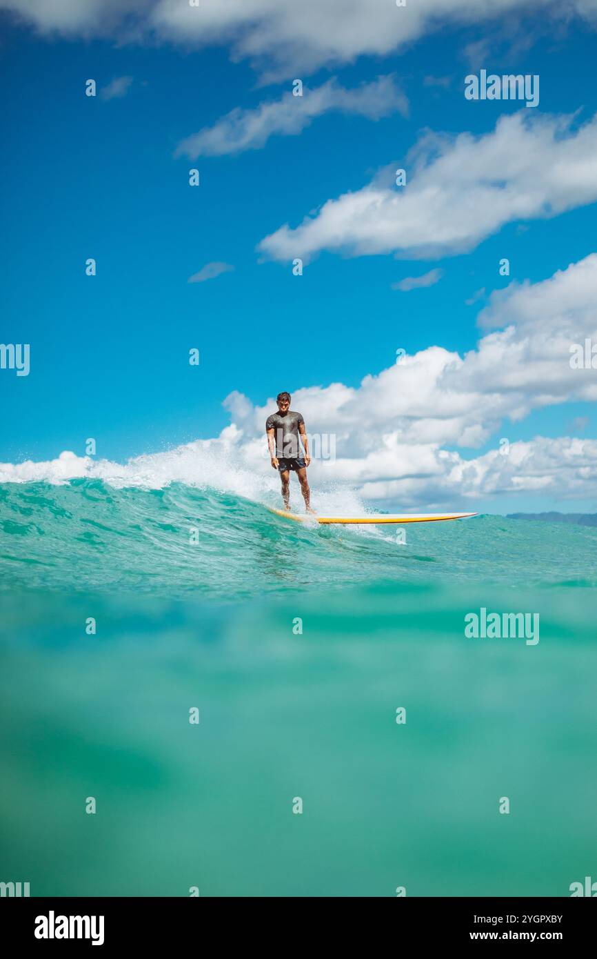 Toots traccia un sentiero su un'onda di Waikiki a Queens Beach Foto Stock
