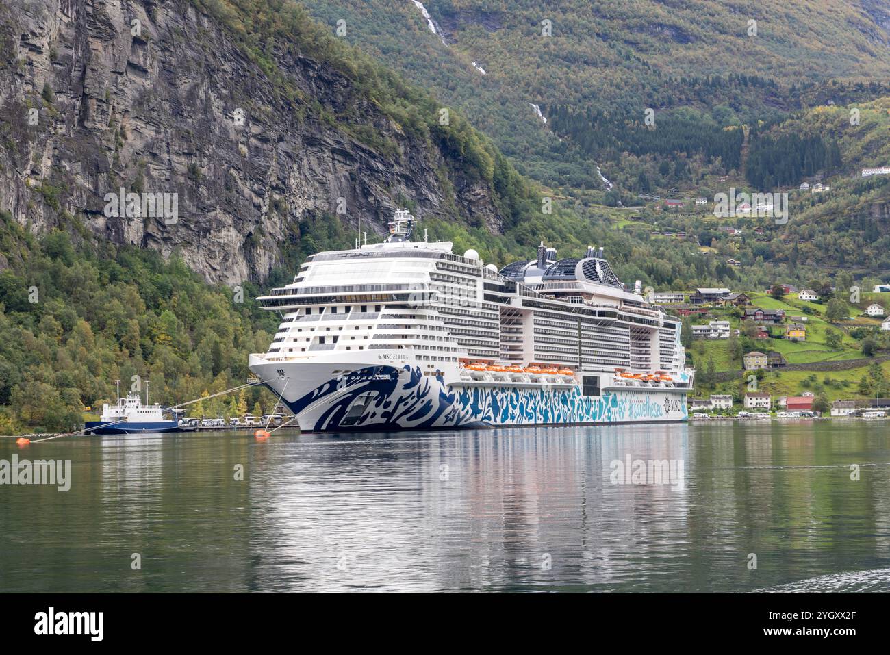 Nave da crociera MSC Euribia nel porto del villaggio norvegese di Geiranger sul Geirangerfjord. MSC Euribia alimentato a gas naturale liquefatto, Norvegia occidentale Foto Stock