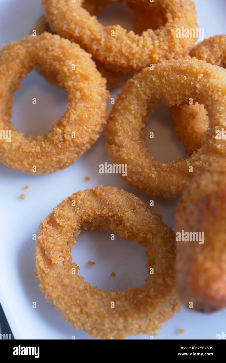 Squisiti anelli di cipolla fritti dorati serviti su un piatto per te Foto Stock