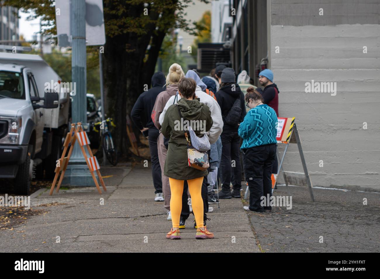 Gli elettori aspettano in fila per entrare nella Multnomah County Elections Division, un ufficio di registrazione degli elettori a Portland, Oregon, il giorno delle elezioni 2024. Foto Stock