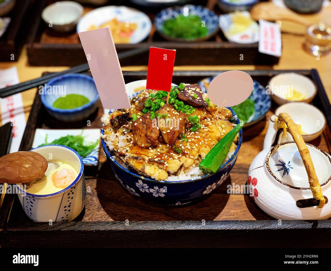 Ciotola di riso giapponese con anguilla grigliata e contorni tradizionali Foto Stock
