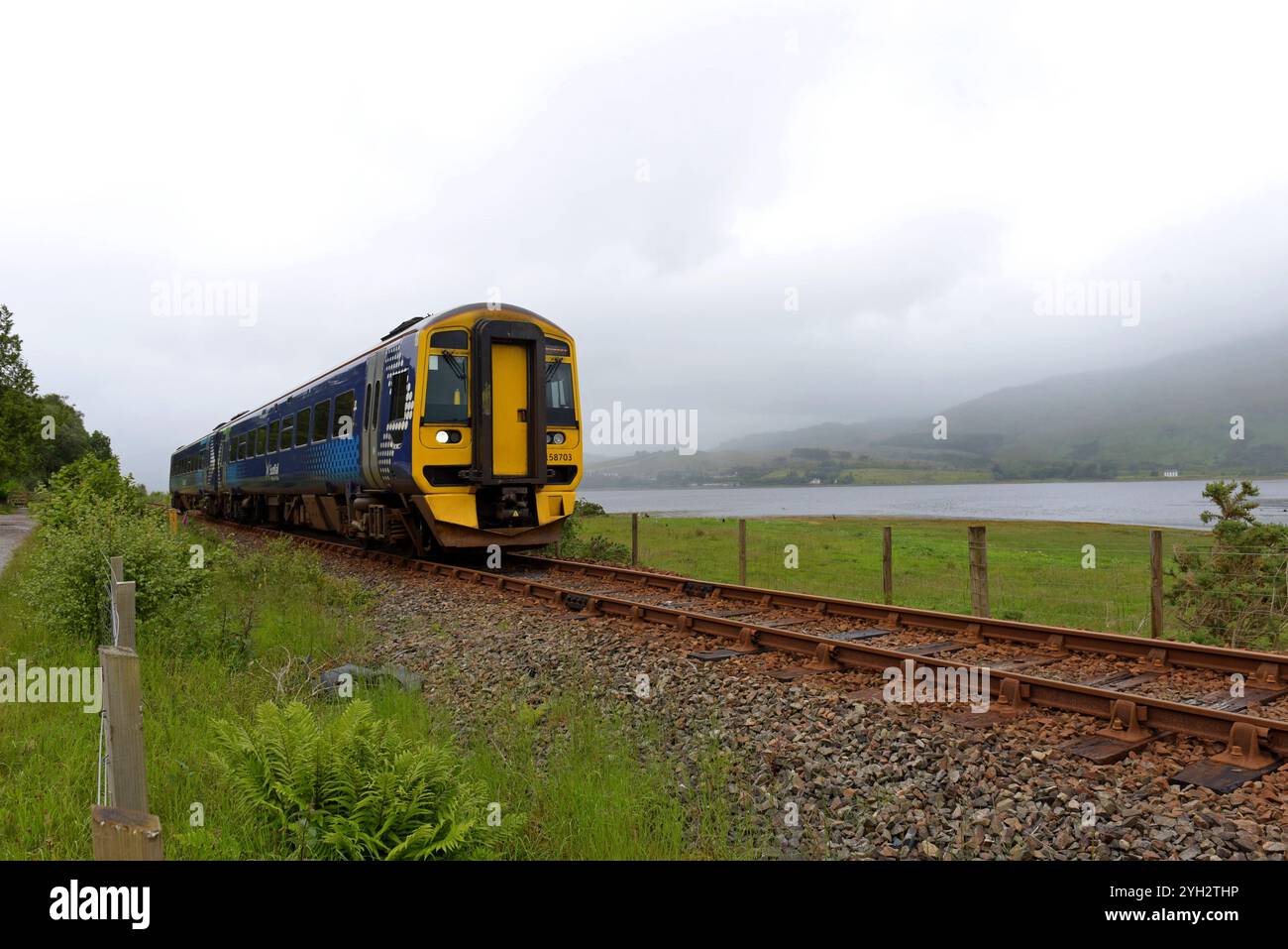 Un treno Scotrail DMU che passa da Loch Carron, vicino a Plockton, Highlands scozzesi, giugno 2024 Foto Stock
