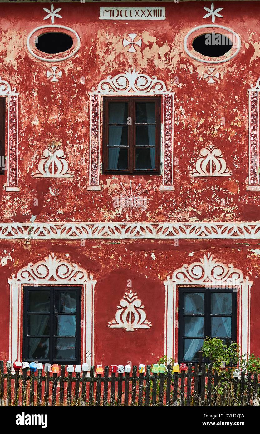 Arte murale sul davanti di una casa con una collezione di tazze sulla recinzione di picchetto in legno. Foto Stock