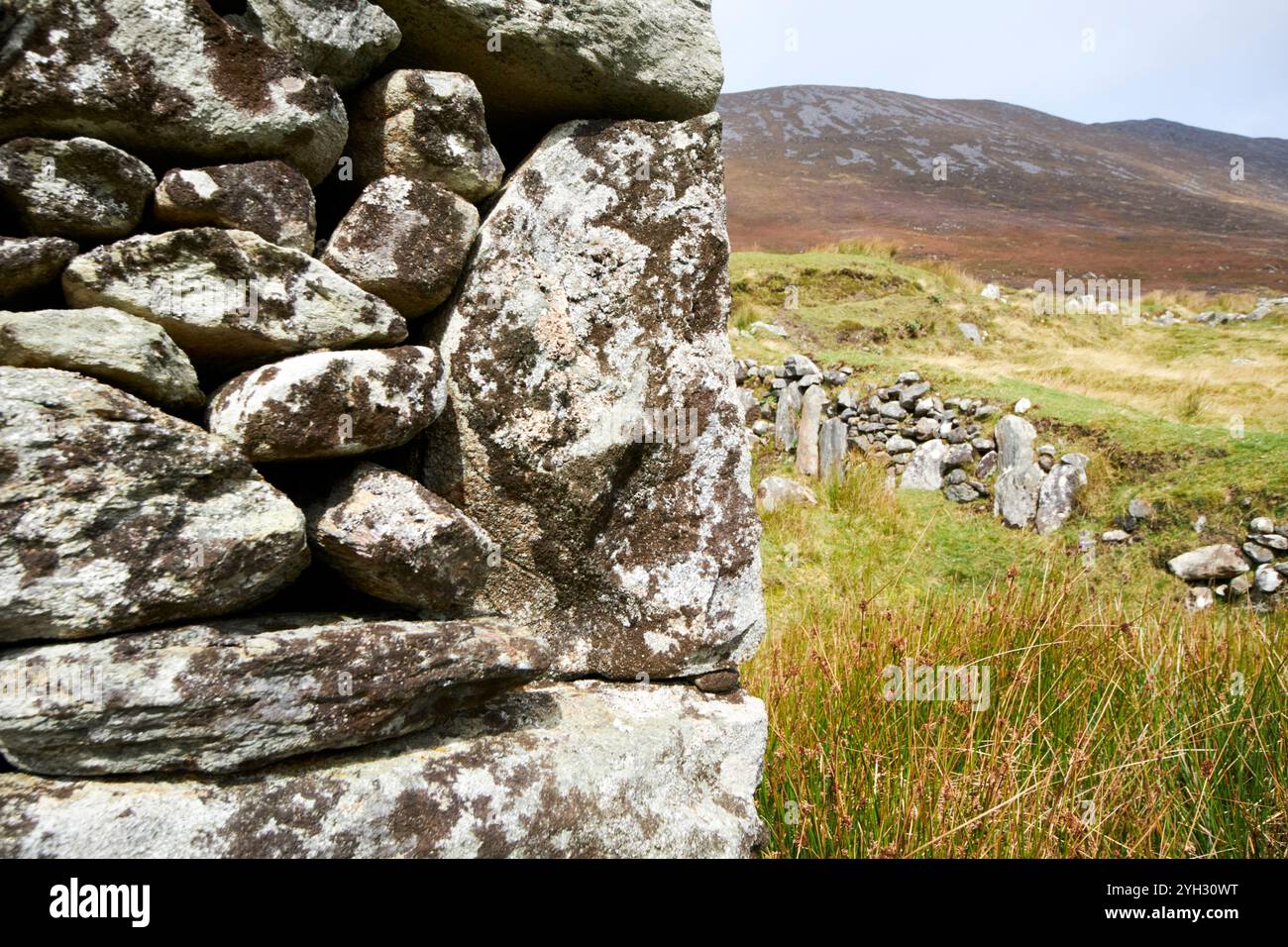 primo piano di pietre angolari di muro di pietra costruzione di una casa in rovina nel villaggio deserto di achill island, contea di mayo, repubblica d'irlanda Foto Stock