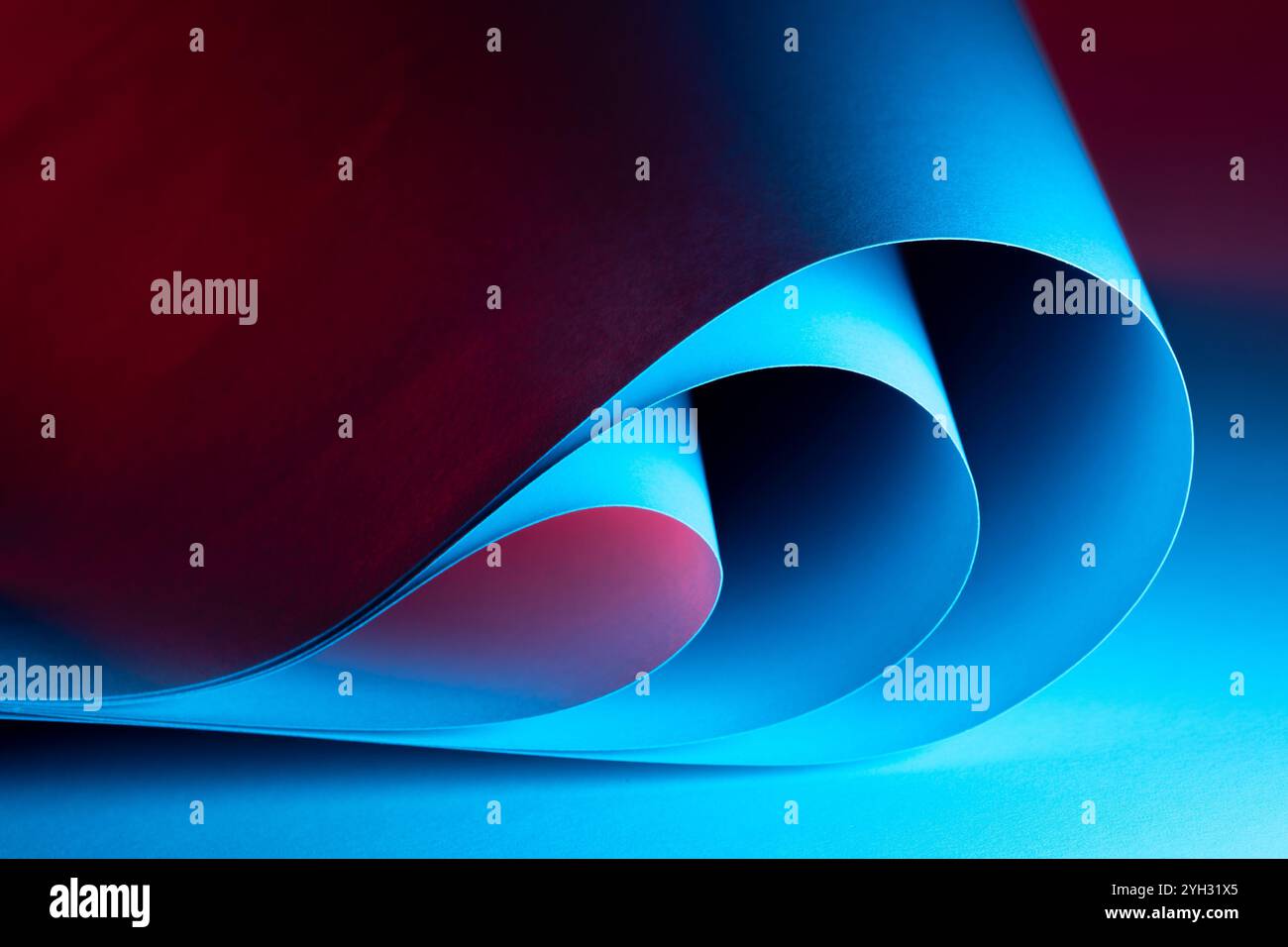 Le forme curve in blu e rosso si fondono armoniosamente, creando una coinvolgente composizione astratta che invita lo spettatore a esplorare textur Foto Stock