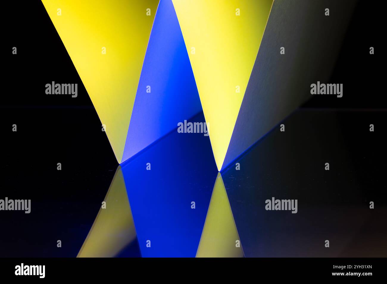 Angoli nitidi e tonalità vivaci in diverse tonalità blu e giallo con nero si combinano per formare una composizione astratta accattivante, che mette in mostra la bellezza di Foto Stock